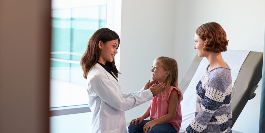 Pediatrician meeting with mother and child in exam room