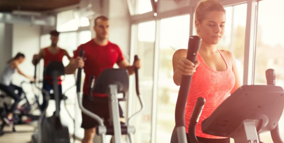 Man and woman doing a cardio exercise at the gym