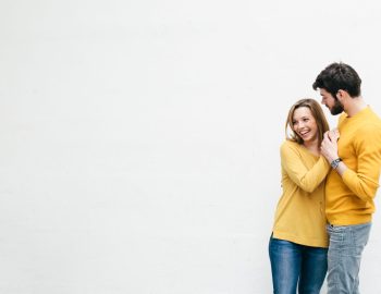 Male and female couple holding hands, male staring at female