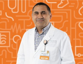 A photo of Doctor Qattach in front of an orange background.