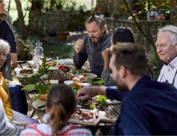 Multi-generational family gathered around a dining table.
