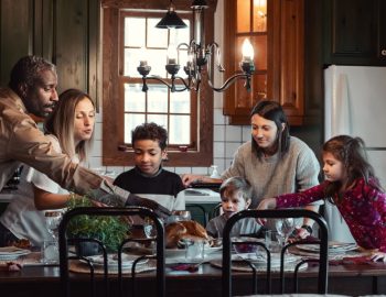 A family of four gathered around the dining table.