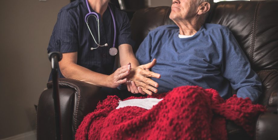 Elder man receiving care from a nurse.