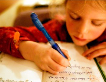 A young girl writing in a journal.