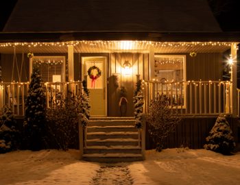 A house covered in snow and holiday decorations.
