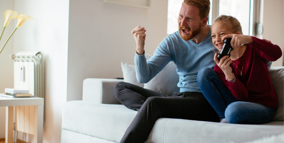 Older man excited as younger girl wins a video game.
