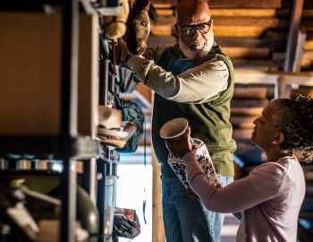 Man and woman storing items on a shelf.