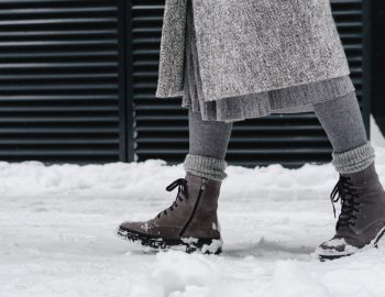 Someone walking through snow with boots on their feet.