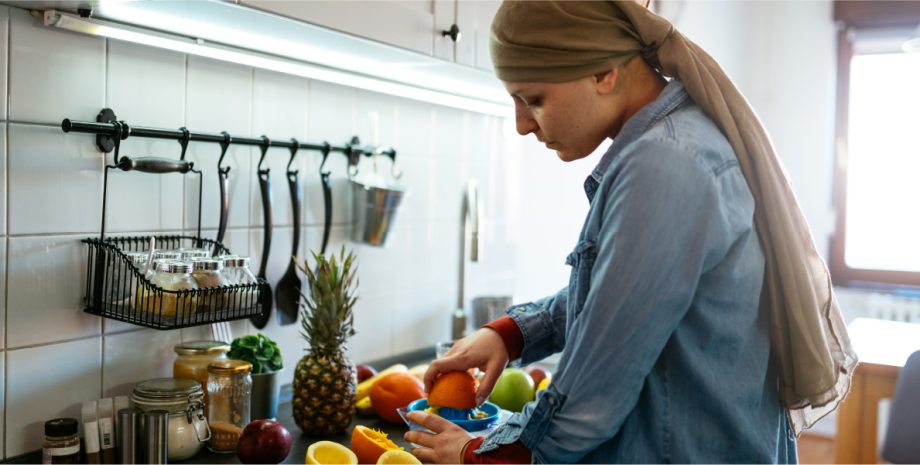 A woman preparing various fruits in her kitchen.