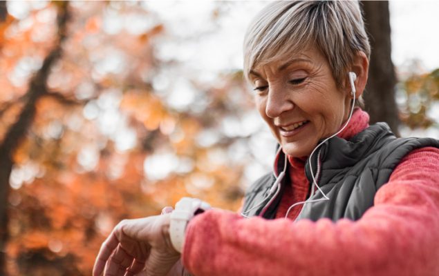 Elderly woman checking her watch to read her heart rate.