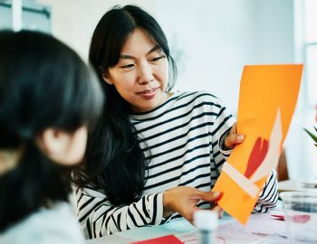 A mother opening a card in front of her child.