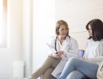 Doctor and patient reviewing medical record in clinic lobby