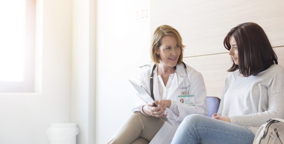 Doctor and patient reviewing medical record in clinic lobby