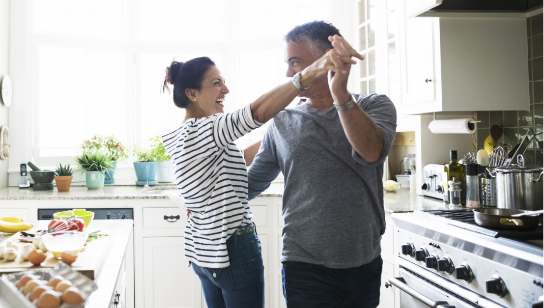 couple dancing in kitchen with food