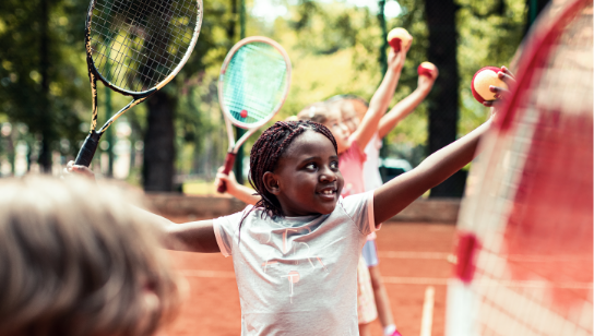 happy children learning how to play tennis