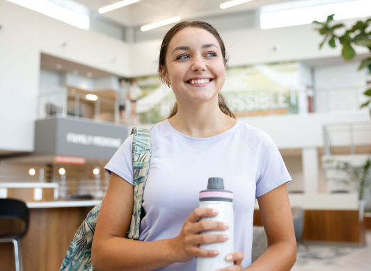 smiling young woman at Wellness Center with water bottle