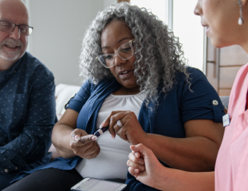 A nurse helping a couple read their diabetes test.