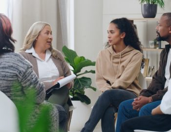 A group of adults sitting in a circle in some sort of discussion.